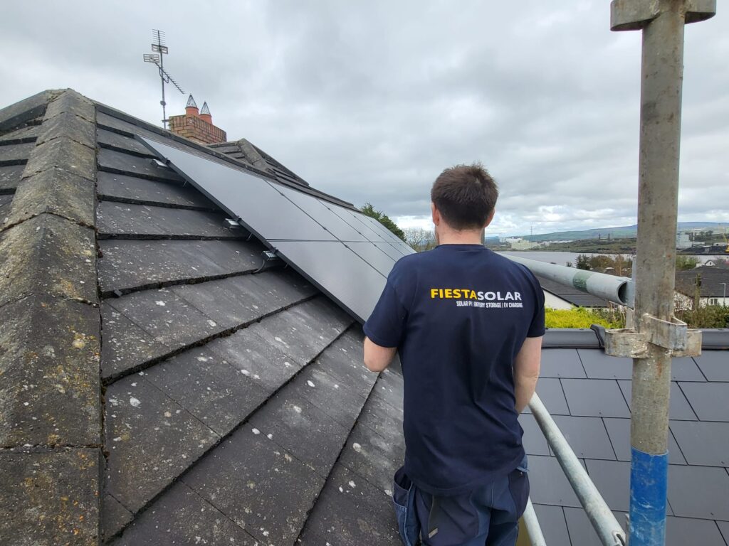 fiesta solar installer on scaffolding next to solar panels